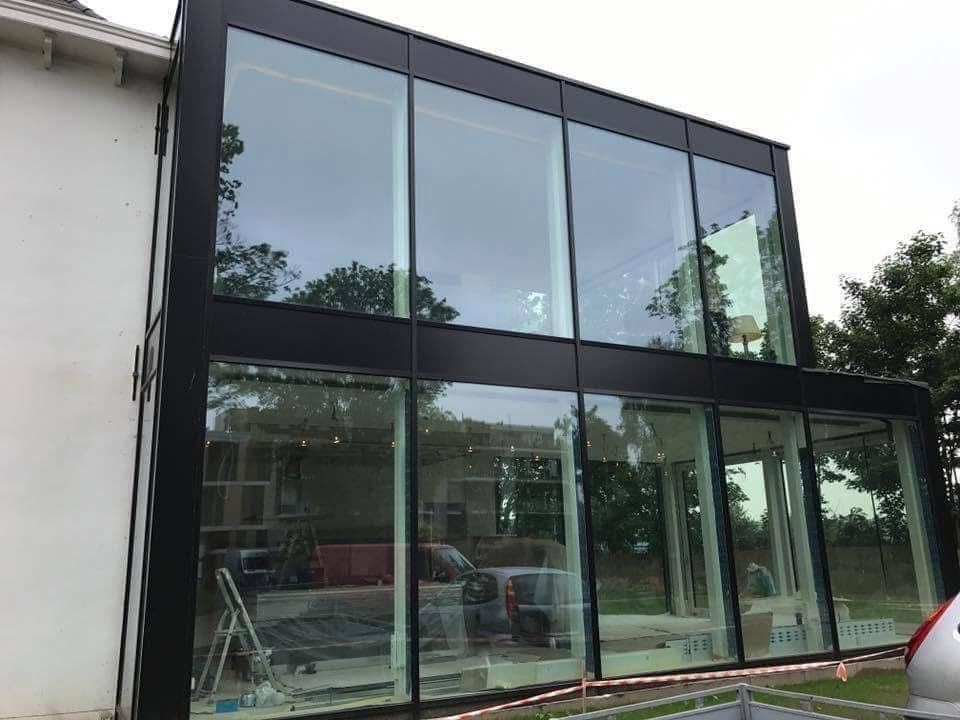 Aluminium gordijngevel over twee verdiepingen met grote glaspanelen in zwart matte profielen